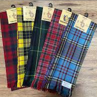 Set of tartan scarves on hangers with tags on a wooden surface